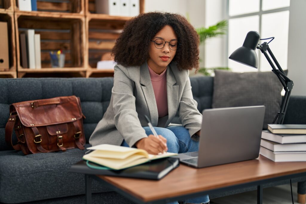 Young african american woman psychologist using laptop at psychology center
