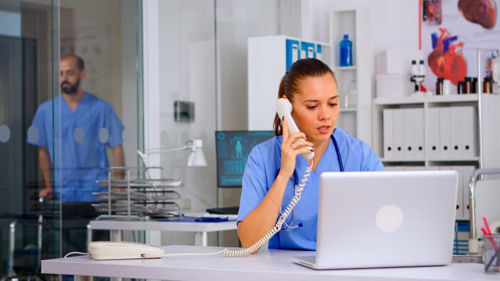Medical biller processing insurance claims on a computer
