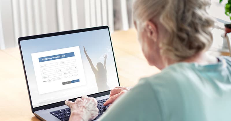 Patient entering information into a digital intake system at a clinic.